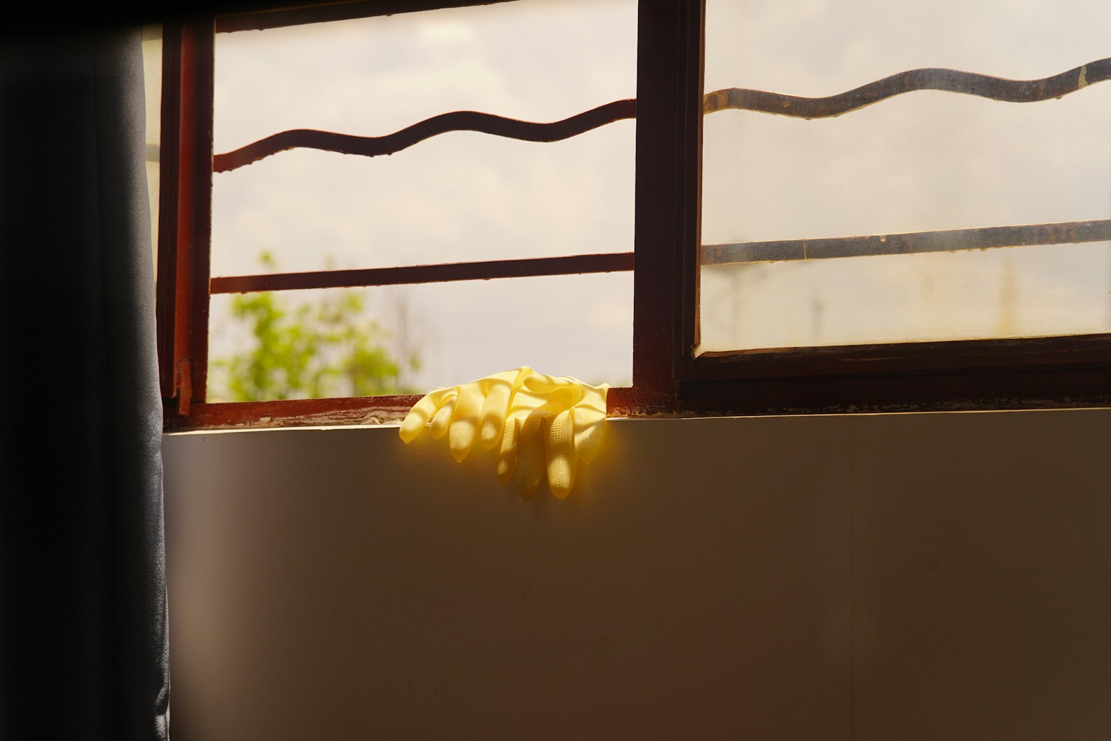 Window and sill with cleaning gloves resting on the ledge