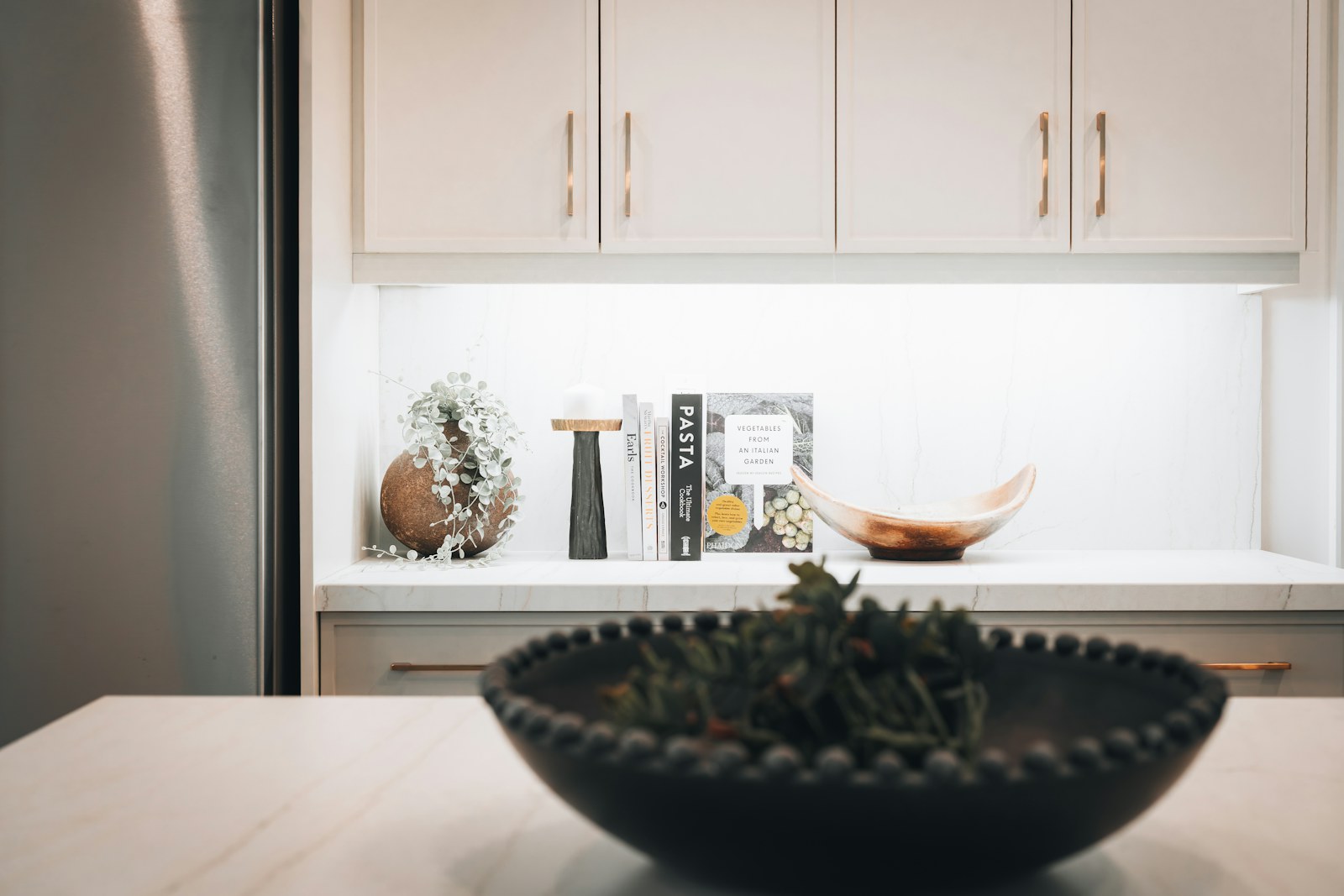 Tidy kitchen counter with books and a bowl in a lived-in home